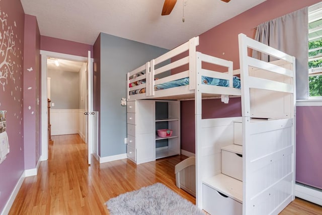 569 Driftwood Rd, New Brighton, MN 55112 - unfurnished bedroom with a baseboard radiator, wood finished floors, and a wainscoted wall