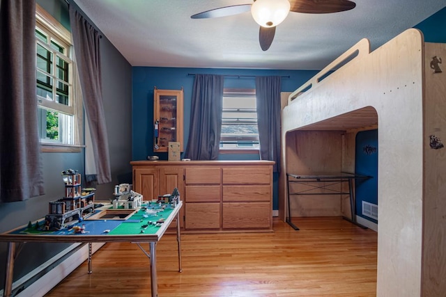 569 Driftwood Rd, New Brighton, MN 55112 - bedroom featuring light wood-type flooring, a baseboard radiator, and arched walkways