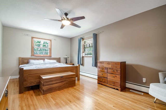 569 Driftwood Rd, New Brighton, MN 55112 - bedroom with a baseboard radiator, light wood-type flooring, ceiling fan, and baseboard heating