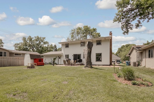 569 Driftwood Rd, New Brighton, MN 55112 - back of house with central air condition unit, a chimney, a patio area, and a fire pit
