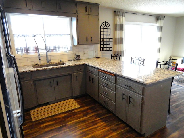 9540 24th Ave N, Plymouth, MN 55441 - kitchen with freestanding refrigerator, a peninsula, gray cabinetry, dark wood-style flooring, and a sink