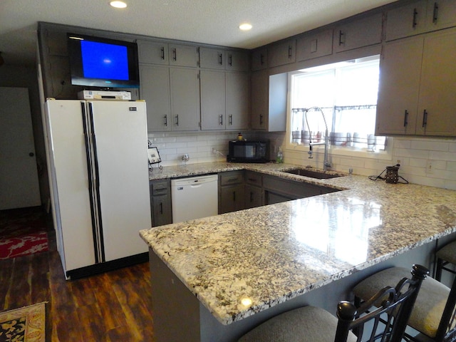 9540 24th Ave N, Plymouth, MN 55441 - kitchen with white appliances, a peninsula, dark wood-type flooring, a sink, and tasteful backsplash
