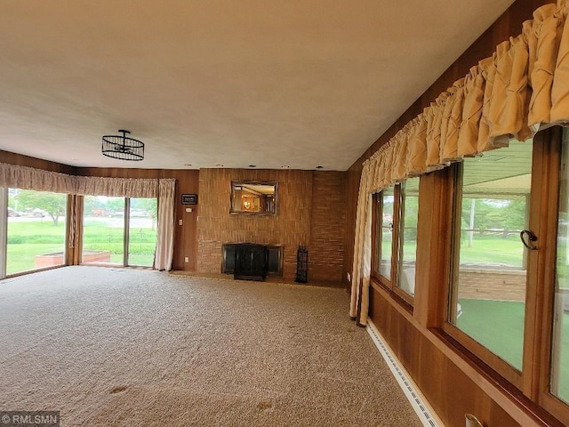 109 Jackson St W, Eagle Bend, MN 56446 - unfurnished living room with carpet flooring, a brick fireplace, healthy amount of natural light, and wooden walls