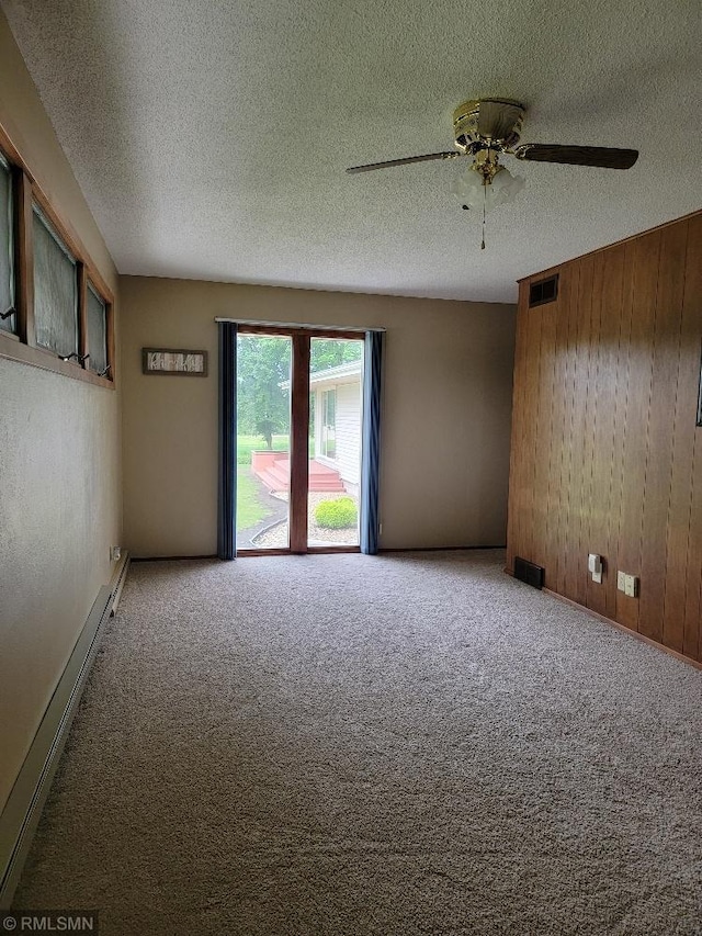 109 Jackson St W, Eagle Bend, MN 56446 - empty room featuring wood walls, carpet floors, ceiling fan, a textured ceiling, and a baseboard radiator