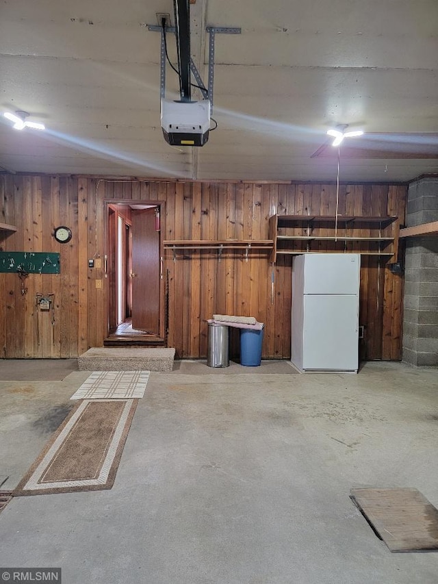 109 Jackson St W, Eagle Bend, MN 56446 - garage with freestanding refrigerator, wooden walls, and a garage door opener