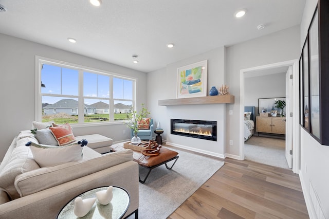 2733 Kama Ave NE, Saint Michael, MN 55376 - living room with light wood-style flooring, a glass covered fireplace, recessed lighting, and baseboards