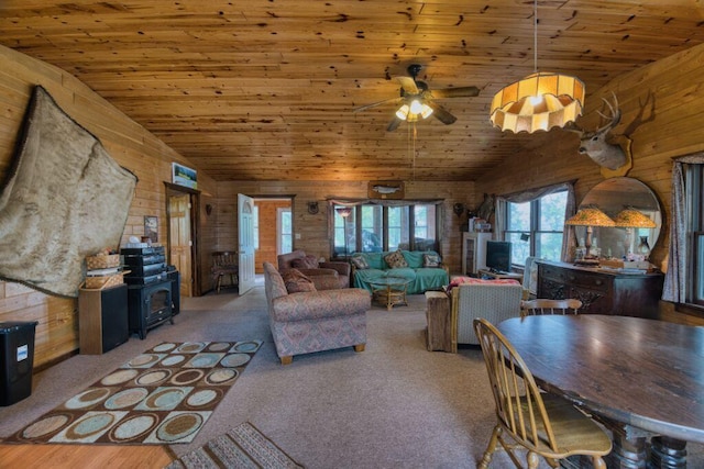 30901 Sunny Beach Rd, Grand Rapids, MN 55744 - living area featuring wood ceiling, a wood stove, wooden walls, a ceiling fan, and carpet flooring