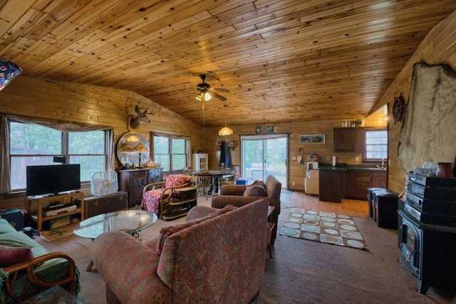 30901 Sunny Beach Rd, Grand Rapids, MN 55744 - living area featuring vaulted ceiling, wood ceiling, wood walls, a ceiling fan, and a wood stove