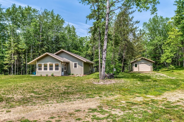 15989 Lost Oaks Dr SE, Cass Lake, MN 56633 - view of front of home featuring a detached garage, an outdoor structure, a front yard, and a wooded view