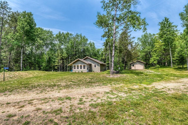 15989 Lost Oaks Dr SE, Cass Lake, MN 56633 - view of green lawn featuring a detached garage, an outdoor structure, and a view of trees