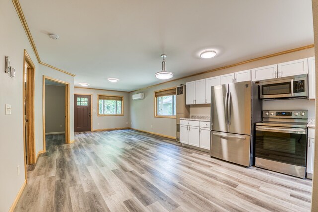15989 Lost Oaks Dr SE, Cass Lake, MN 56633 - kitchen with stainless steel appliances, crown molding, baseboards, light wood-type flooring, and a wall unit AC