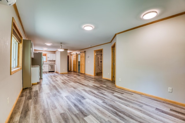 15989 Lost Oaks Dr SE, Cass Lake, MN 56633 - unfurnished living room featuring light wood-style floors, ornamental molding, a barn door, baseboards, and a wall unit AC