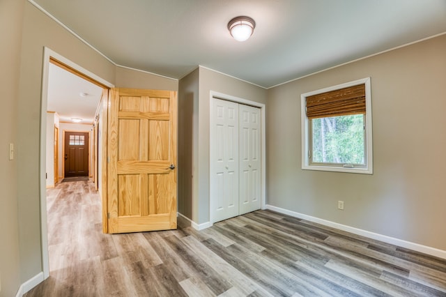 15989 Lost Oaks Dr SE, Cass Lake, MN 56633 - unfurnished bedroom with wood finished floors, crown molding, a closet, and baseboards