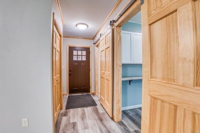 15989 Lost Oaks Dr SE, Cass Lake, MN 56633 - entryway featuring a barn door, light wood-style floors, crown molding, and baseboards