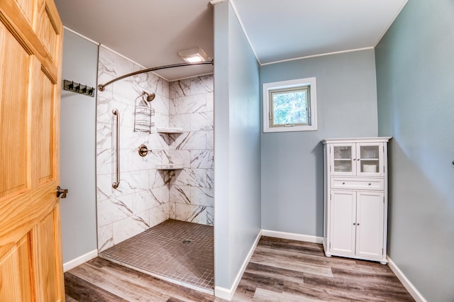 15989 Lost Oaks Dr SE, Cass Lake, MN 56633 - bathroom featuring a tile shower, wood finished floors, baseboards, and ornamental molding