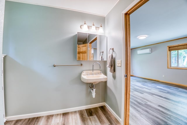 15989 Lost Oaks Dr SE, Cass Lake, MN 56633 - bathroom featuring a wall mounted air conditioner, wood finished floors, and baseboards