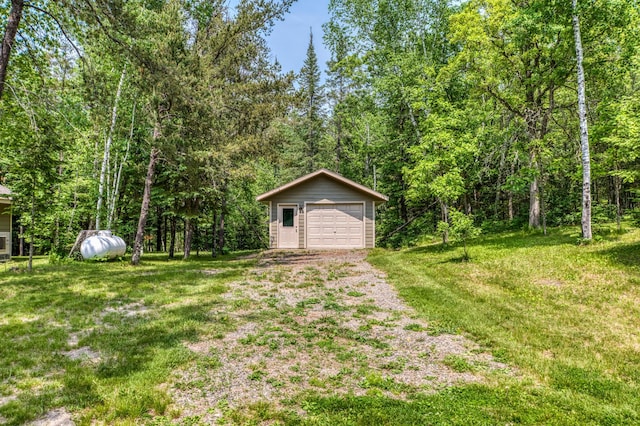 15989 Lost Oaks Dr SE, Cass Lake, MN 56633 - view of yard featuring a garage, an outbuilding, driveway, and a wooded view