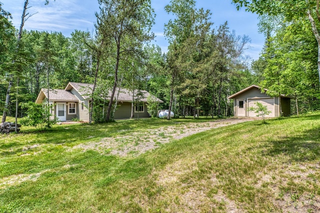 15989 Lost Oaks Dr SE, Cass Lake, MN 56633 - view of grassy yard featuring a detached garage, an outdoor structure, and dirt driveway