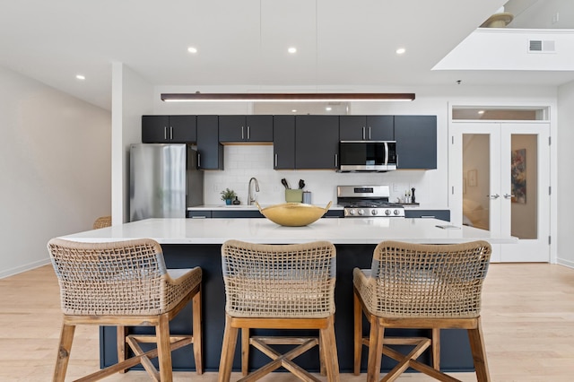 3104 Lake St Unit 412, Minneapolis, MN 55416 - kitchen with stainless steel appliances, dark cabinets, light countertops, decorative backsplash, and french doors