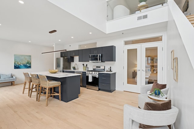 3104 Lake St Unit 412, Minneapolis, MN 55416 - kitchen featuring stainless steel appliances, open floor plan, a breakfast bar, a kitchen island, and light countertops