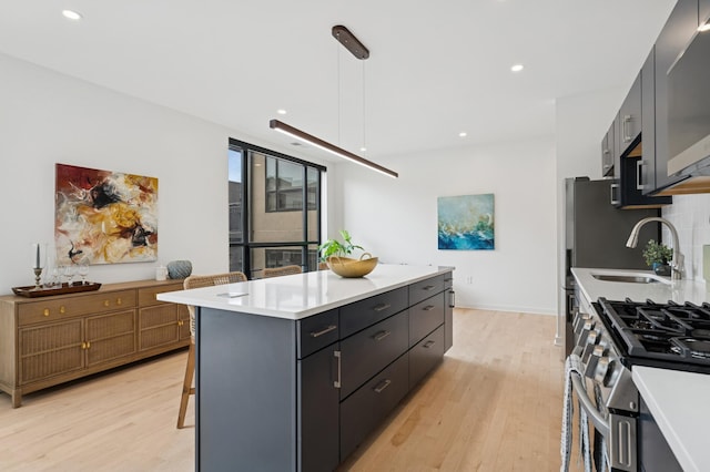 3104 Lake St Unit 412, Minneapolis, MN 55416 - kitchen with light wood-style floors, light countertops, a center island, gas range, and pendant lighting