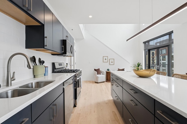 3104 Lake St Unit 412, Minneapolis, MN 55416 - kitchen with a sink, stainless steel appliances, light countertops, tasteful backsplash, and light wood-style floors