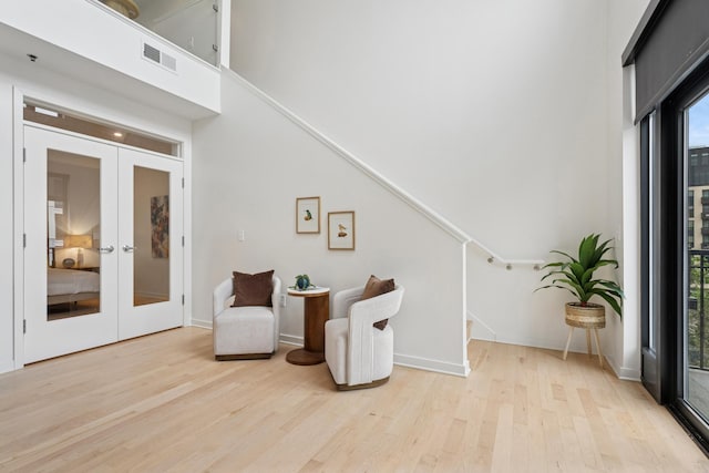 3104 Lake St Unit 412, Minneapolis, MN 55416 - living area with light wood-type flooring, a high ceiling, french doors, stairs, and baseboards
