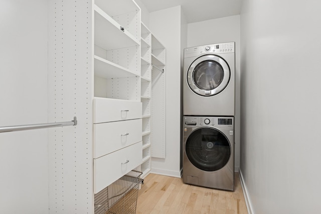 3104 Lake St Unit 412, Minneapolis, MN 55416 - laundry area with stacked washer / dryer, light wood-style floors, and baseboards