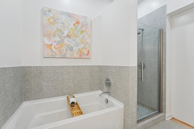 3104 Lake St Unit 412, Minneapolis, MN 55416 - bathroom featuring a stall shower, a garden tub, and a wainscoted wall