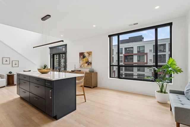 3104 Lake St Unit 412, Minneapolis, MN 55416 - kitchen featuring light wood finished floors, dark cabinets, a center island, open floor plan, and recessed lighting