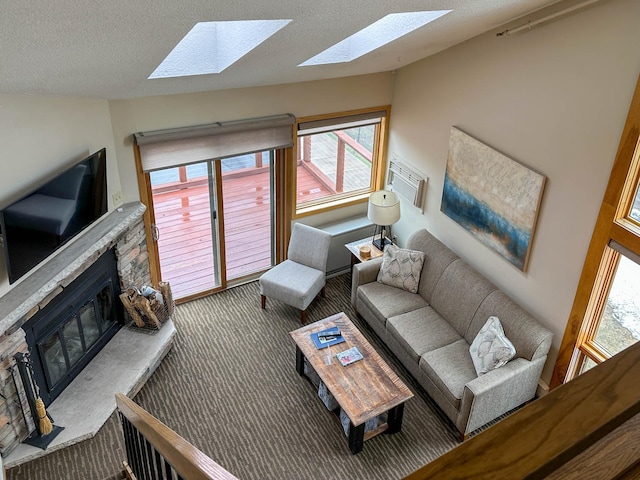 122 Bridge Run Ln Unit A, Lutsen Twp, MN 55615 - carpeted living room featuring a skylight, vaulted ceiling, a fireplace, and a textured ceiling