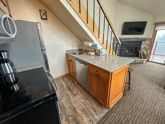 122 Bridge Run Ln Unit A, Lutsen Twp, MN 55615 - kitchen with appliances with stainless steel finishes, vaulted ceiling, brown cabinets, open floor plan, and a sink