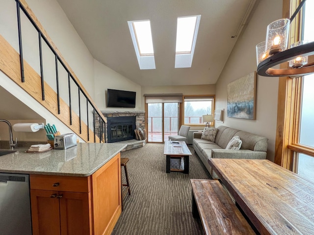 122 Bridge Run Ln Unit A, Lutsen Twp, MN 55615 - living room featuring dark colored carpet, a fireplace, high vaulted ceiling, a skylight, and stairs