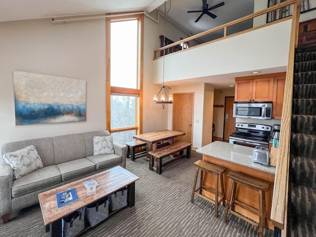 122 Bridge Run Ln Unit A, Lutsen Twp, MN 55615 - living area with dark colored carpet, high vaulted ceiling, a ceiling fan, and a chandelier