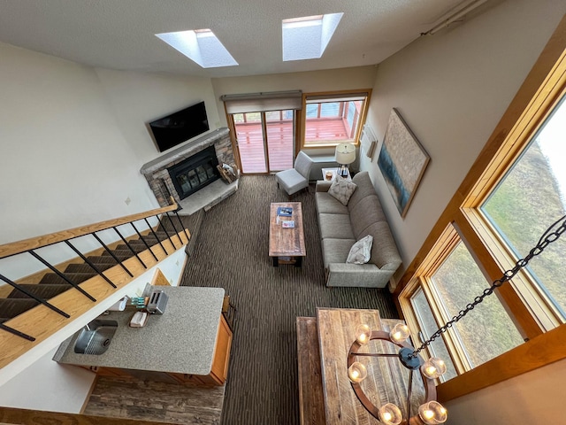 122 Bridge Run Ln Unit A, Lutsen Twp, MN 55615 - living area featuring a fireplace with raised hearth, a skylight, and stairs