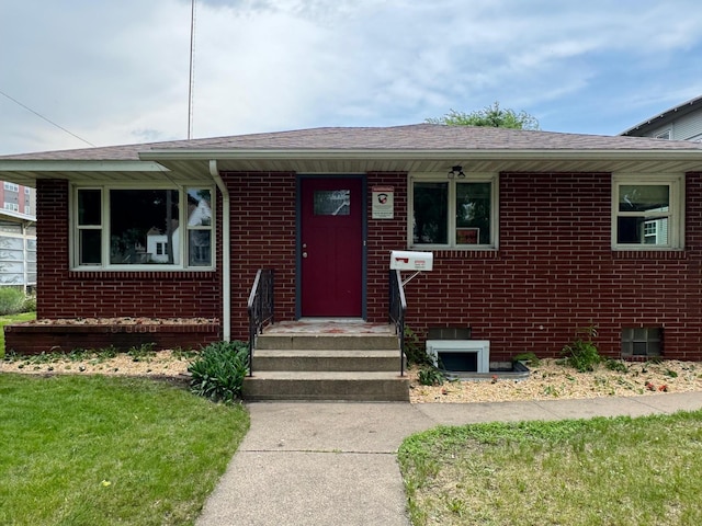 348 6th Ave S, Saint Cloud, MN 56301 - property entrance with brick siding, a shingled roof, and a lawn