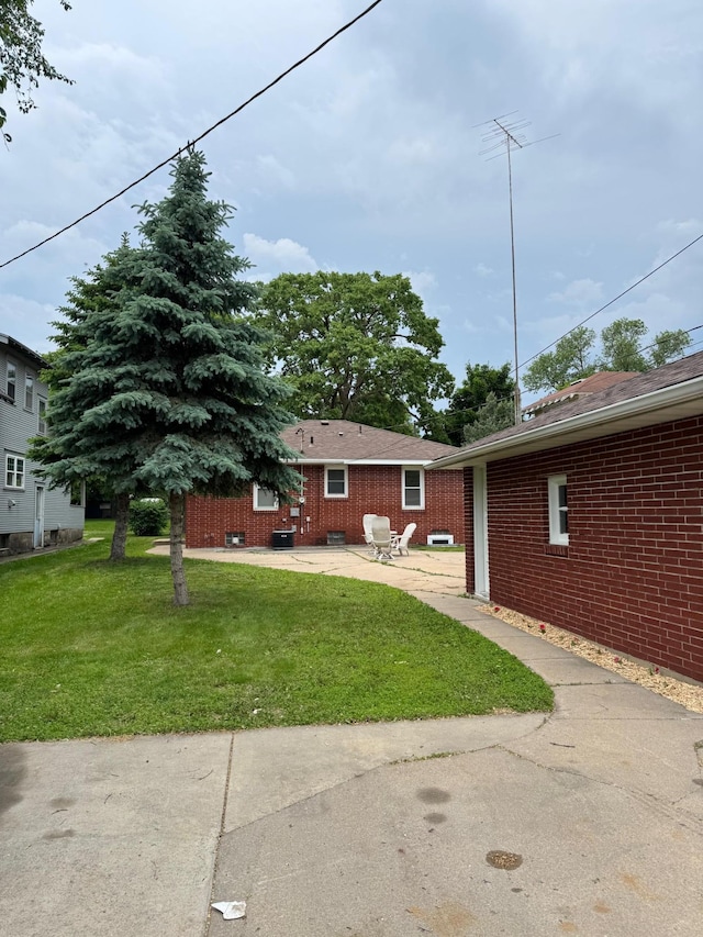 348 6th Ave S, Saint Cloud, MN 56301 - rear view of property featuring a patio, brick siding, and a yard