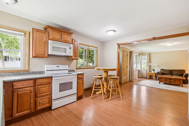348 6th Ave S, Saint Cloud, MN 56301 - kitchen featuring white appliances, light wood finished floors, open floor plan, and brown cabinets