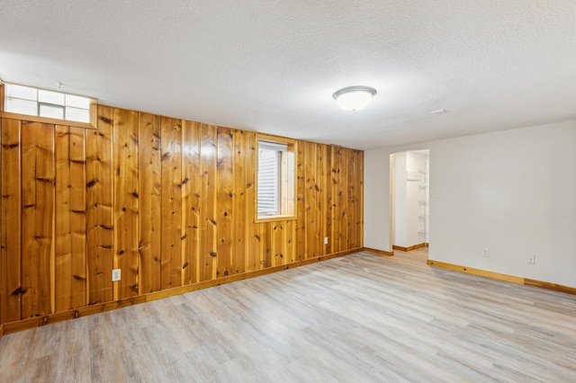 348 6th Ave S, Saint Cloud, MN 56301 - empty room featuring wood finished floors, baseboards, a textured ceiling, and wood walls