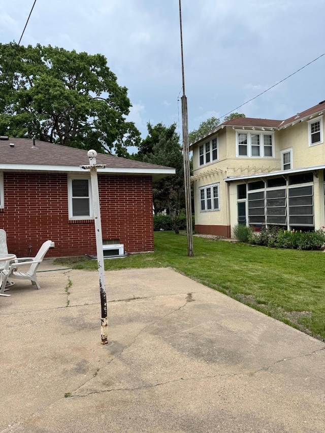 348 6th Ave S, Saint Cloud, MN 56301 - rear view of house featuring a lawn, brick siding, and a patio area