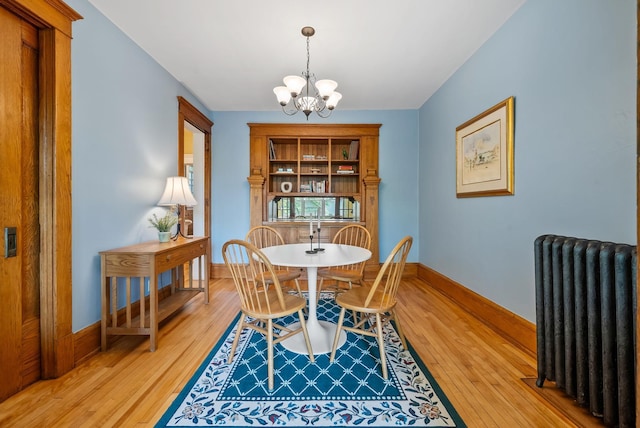 1112 25th St Unit 203, Minneapolis, MN 55405 - dining space with radiator, a chandelier, light wood-style flooring, and baseboards