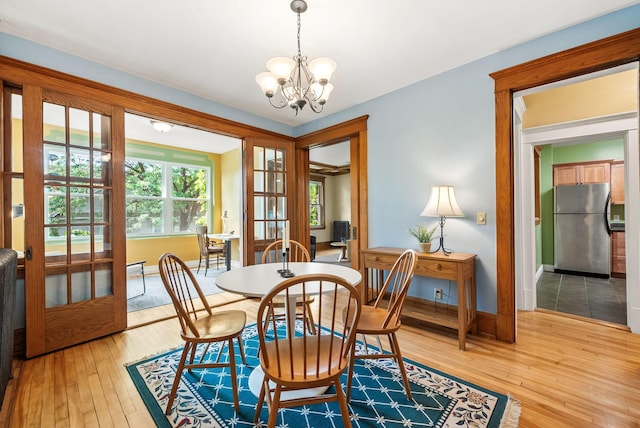 1112 25th St Unit 203, Minneapolis, MN 55405 - dining room with light wood-type flooring, a chandelier, and baseboards