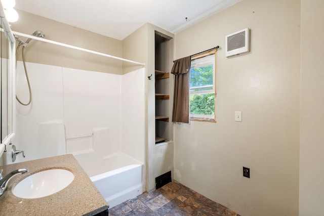 7627 Main St, Danbury, WI 54830 - bathroom featuring stone tile flooring, shower / bath combination, vanity, heating unit, and baseboards