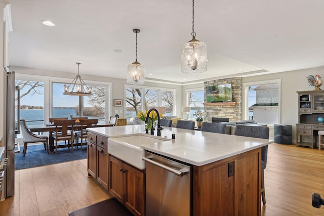 3100 Island View Dr, Mound, MN 55364 - kitchen with stainless steel dishwasher, a sink, recessed lighting, a stone fireplace, and light countertops