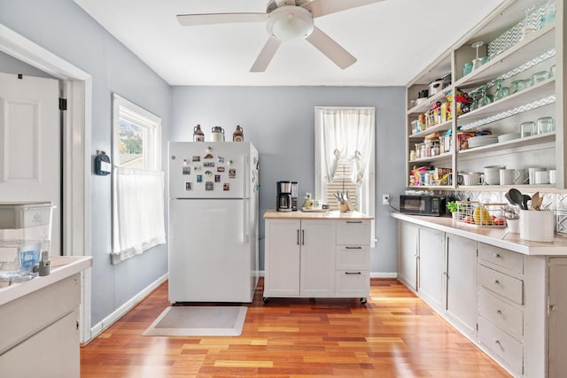 662 24th Ave NE, Minneapolis, MN 55418 - kitchen featuring freestanding refrigerator, light wood finished floors, open shelves, black microwave, and ceiling fan