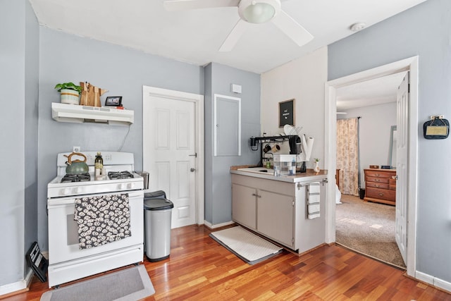 662 24th Ave NE, Minneapolis, MN 55418 - kitchen with white range with gas cooktop, under cabinet range hood, light wood-type flooring, ceiling fan, and light countertops