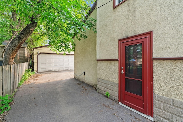 662 24th Ave NE, Minneapolis, MN 55418 - doorway to property with stucco siding, a garage, and driveway