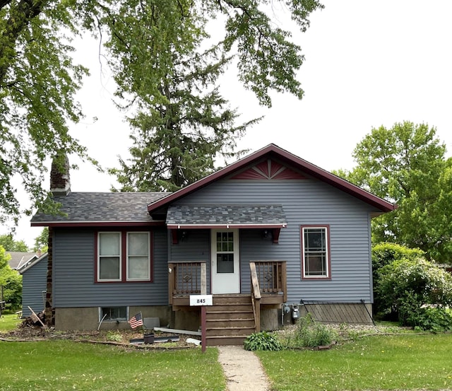 845 12th St, Windom, MN 56101 - bungalow-style home featuring a front yard, a chimney, a porch, and a shingled roof