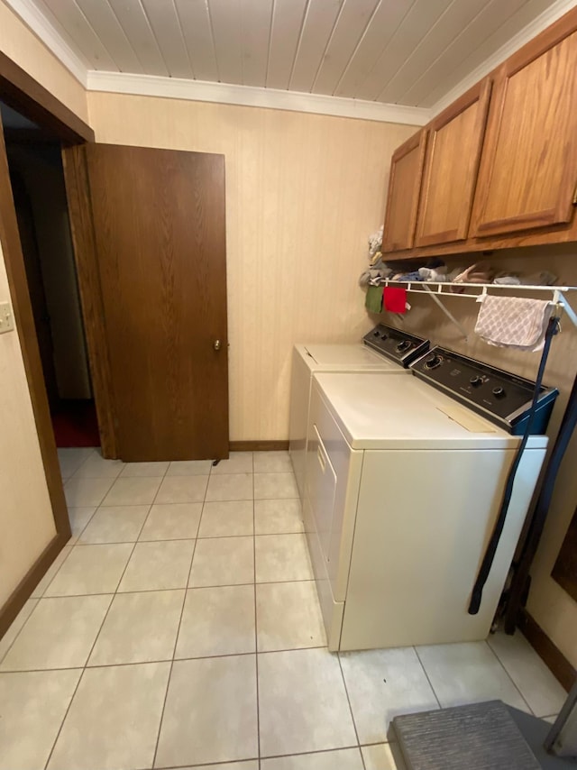 1004 9th St 1006, International Falls, MN 56649 - washroom with cabinet space, washing machine and dryer, ornamental molding, baseboards, and light tile patterned floors