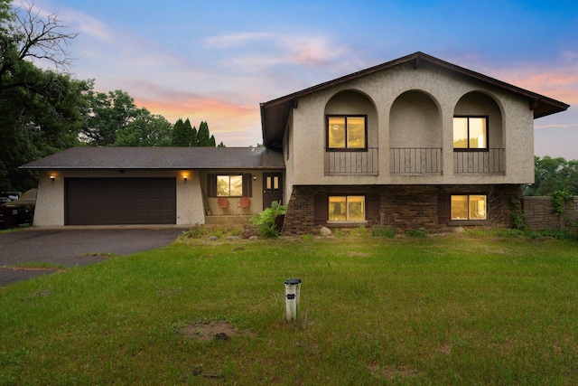 7567 Lent Trl, Lent Twp, MN 55079 - tri-level home with asphalt driveway, a balcony, a garage, stucco siding, and a front yard